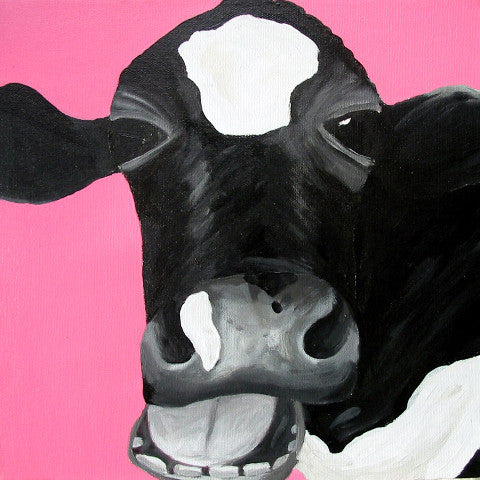 A photographic print of a Friesian cow painted in monochrome against a bright pink background. The cow appears to be laughing.